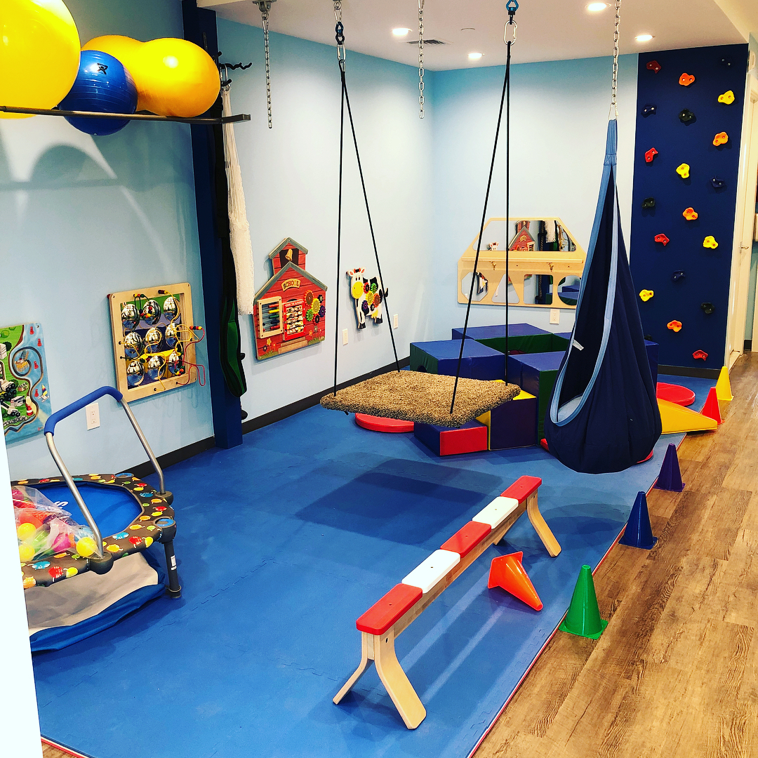 A room with swings and climbing walls in it