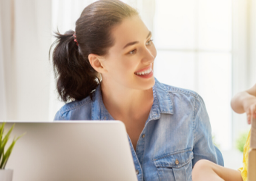 A woman sitting at a table with a laptop.