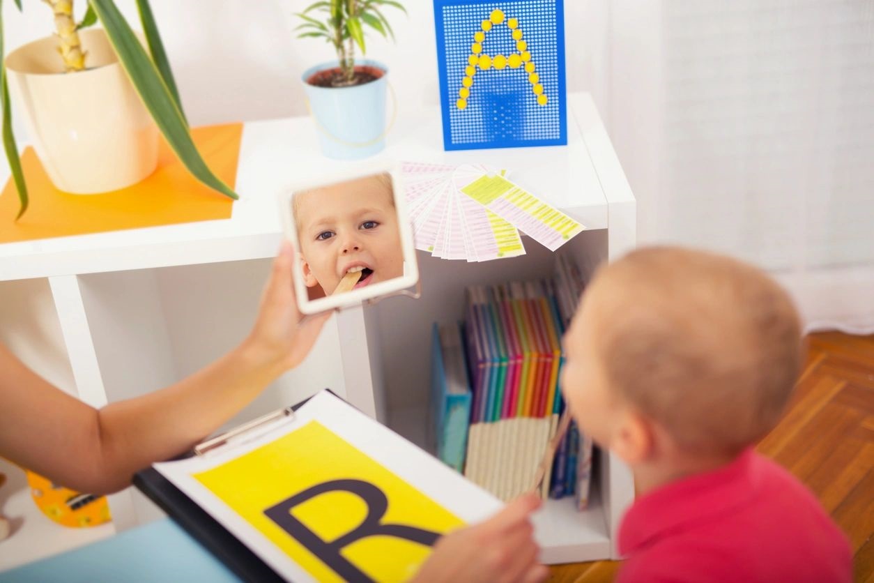 A child is looking at his reflection in the mirror.