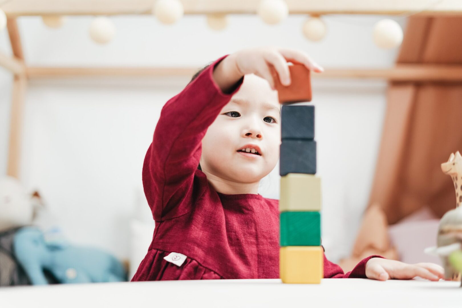 A young child playing with blocks on the table.