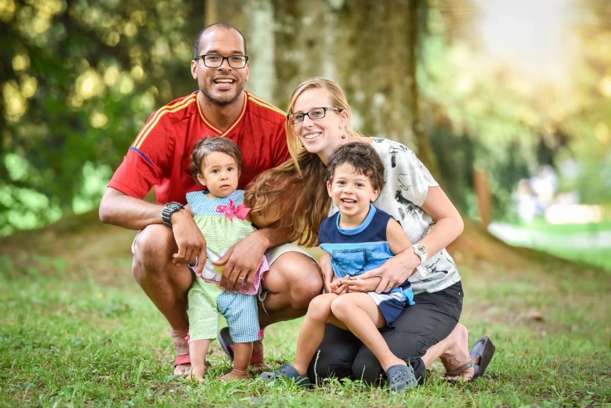 A family posing for a picture in the grass.