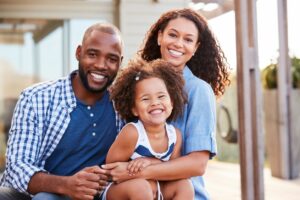 A family of three is smiling for the camera.