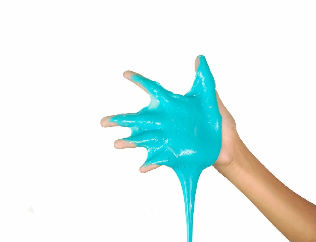 A person with their hand in blue liquid.